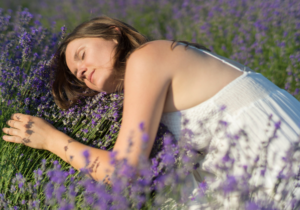 qual o melhor dia para tomar banho de alfazema? mulher encostada em flores de alfazema no campo